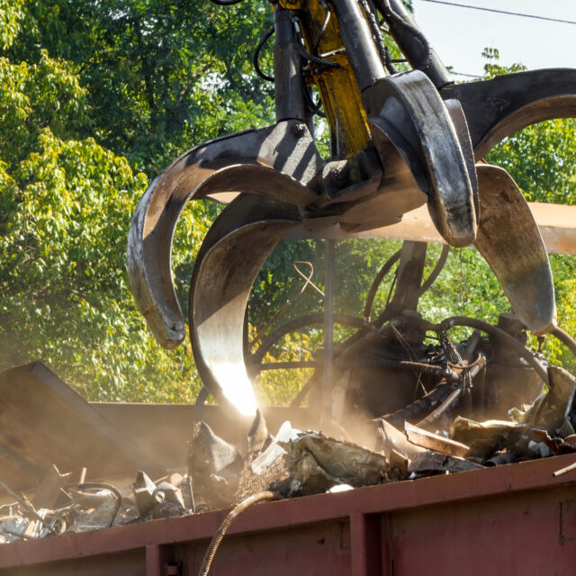 Special claw gripper working on metal scrapyard with old rusty pieces
