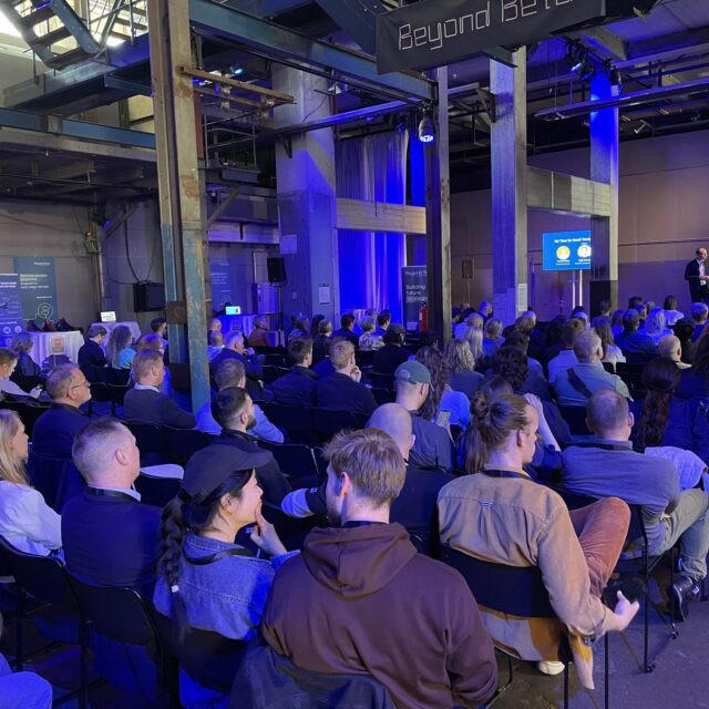 Participants at Beyond Beta Summit 2025, listening to a speak