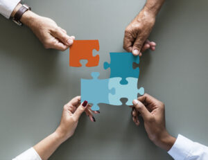 Four hands putting together a puzzle