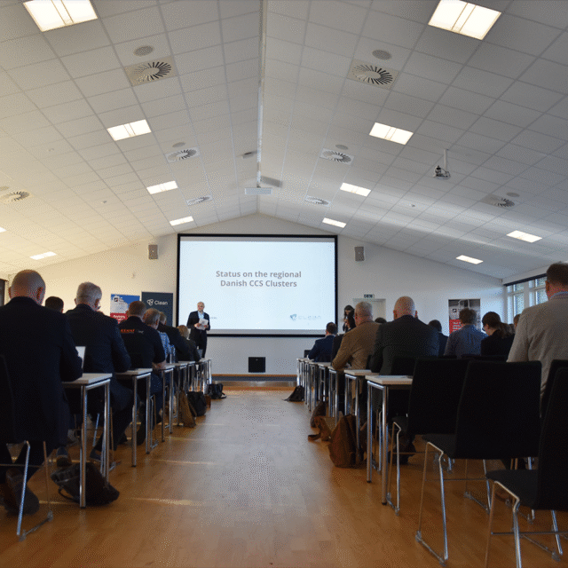 a room with a dias show and lots of people